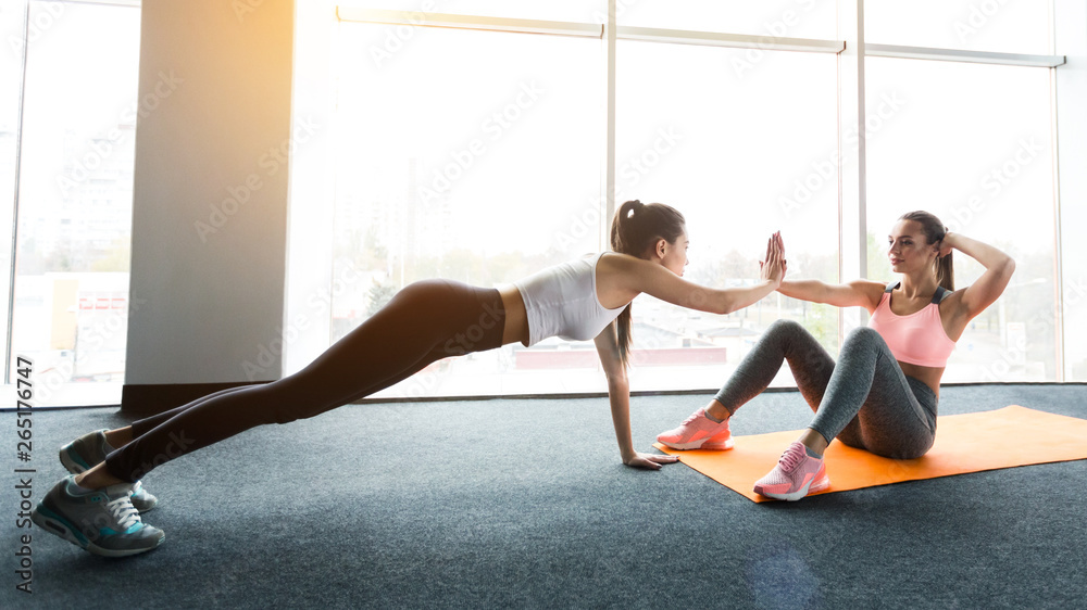 Obraz premium Training together. Girls doing abs workout and plank
