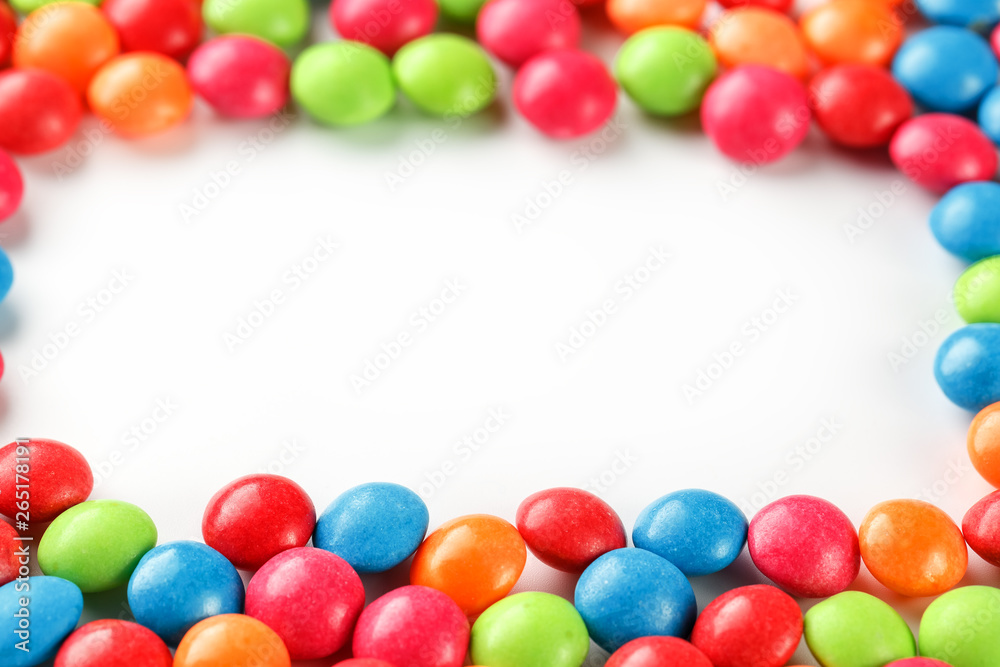 Frame of multi-colored candies close up. Rainbow colored dragee multicolored glaze on a white background Frame of multi-colored candies close up. Rainbow colored dragee multicolored glaze on a white background