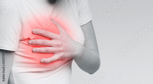 Young woman with breast pain touching chest