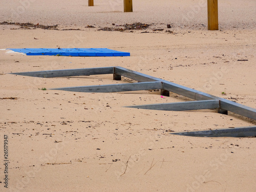 Trozos de madera tragados por la arena de la playa después de un temporal photo