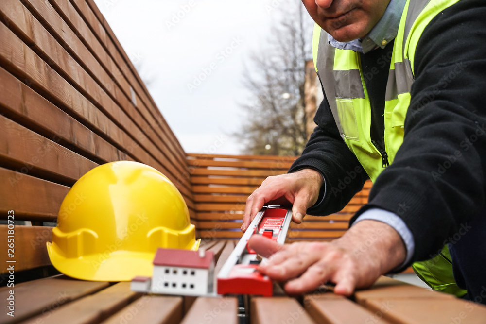 New house construction: builder measuring with a tubular spirit level New house construction: builder measuring with a tubular spirit level