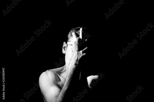 black and white photo, a man holds his hands in the face in an expressive pose
