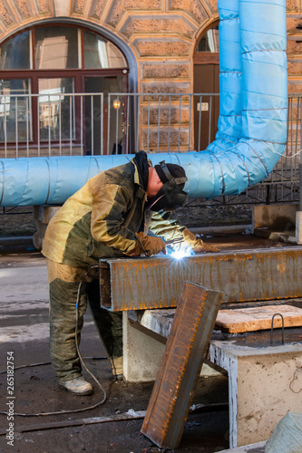welder working with full protective equipment on the street of the city of St. Petersburg.