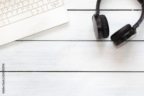 Laptop and misic headphones on white wooden desk. Top view. Free place for text photo