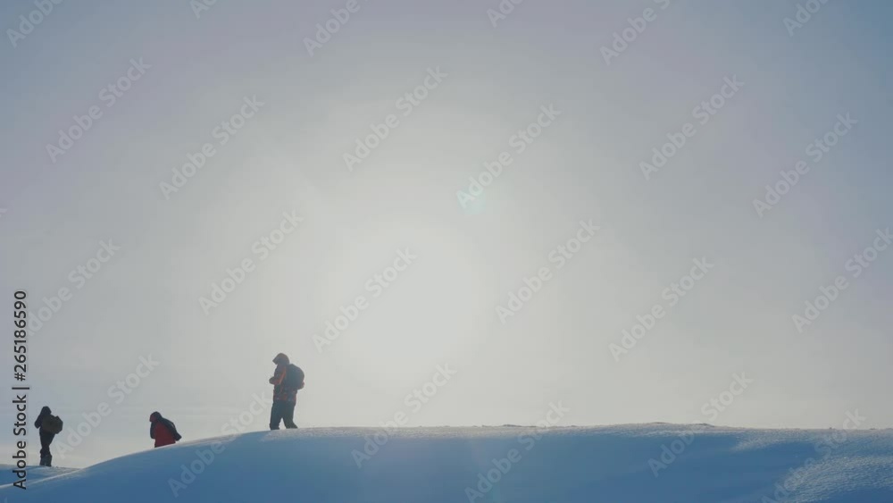 teamwork. men tourists climbing walking top mountains rocks peak group team sunlight silhouette lifestyle on snow feet winter snow trip. slow motion video. people teamwork business travel the teamwork. men tourists climbing walking top mountains rocks peak group team sunlight silhouette lifestyle on snow feet winter snow trip. slow motion video. people teamwork business travel the