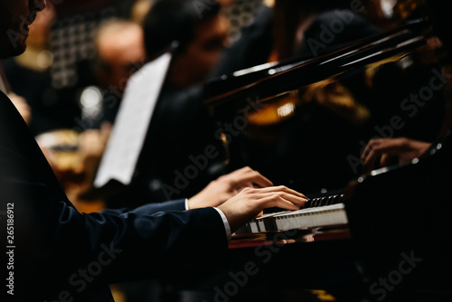 Fotografia Pianist playing a piece on a grand piano at a concert, seen from the side