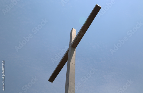 cruz de piedra en diagonal con cielo de fondo