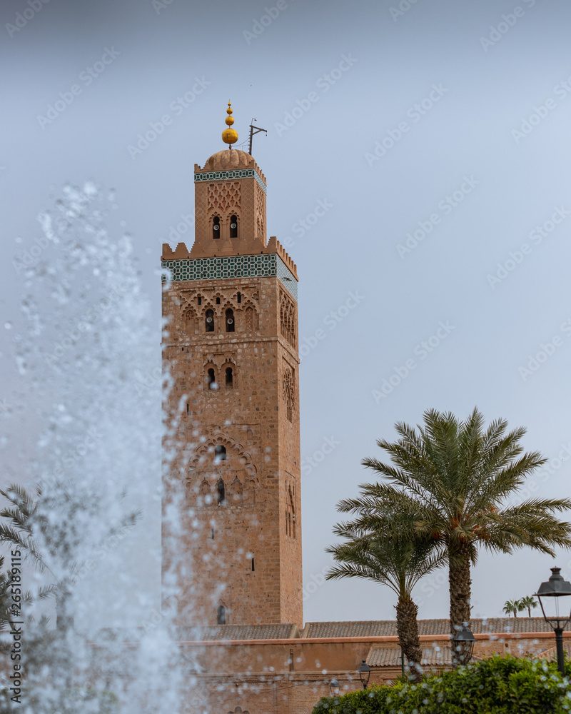 Koutoubia mosque in Marrakesh, Morocco, surrounded by palm trees and a water fountain