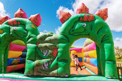 Fototapeta Naklejka Na Ścianę i Meble -  Bouncy castle in the shape of dinosaurs in a children's playground outdoors.