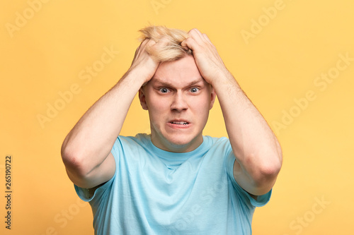 angry furious man with blue eyes pulling his hair out as he is fed up something. man hates somebody, you makes me mad,frustration, negative emotion and feeling
