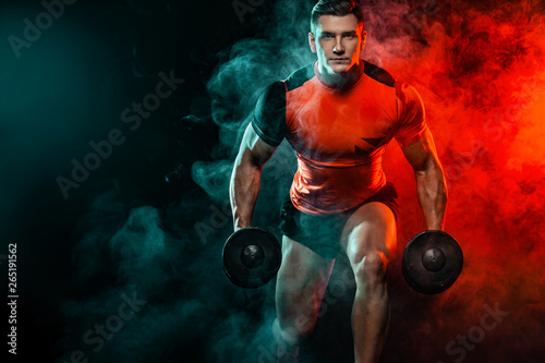 Muscular fitness sports man, atlete with dumbbell in fitness gym. Energy and power.