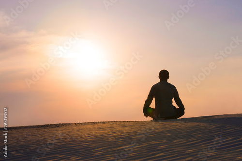 man in the lotus position at sunset © Serhii  Holdin