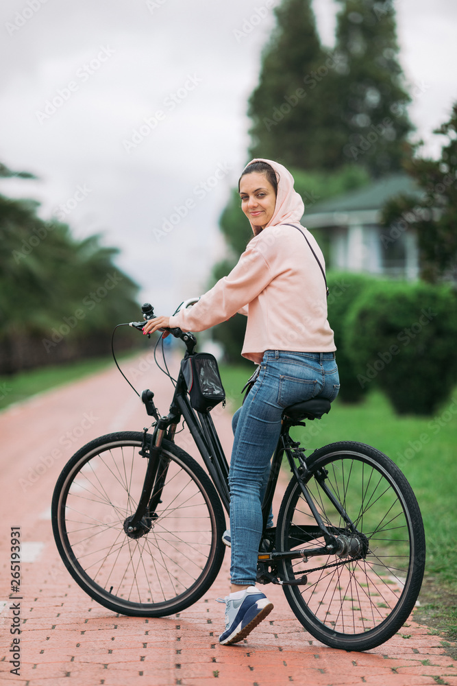 Obraz premium woman cyclist riding a bike on bike path on the embankment