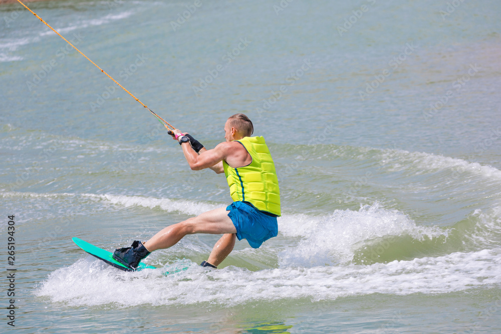Fototapeta premium Man study wakeboarding on a blue lake