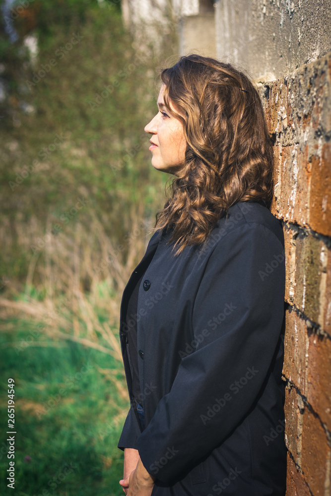 Portrait of beautiful brown hair young woman leaning wall Portrait of beautiful brown hair young woman leaning wall