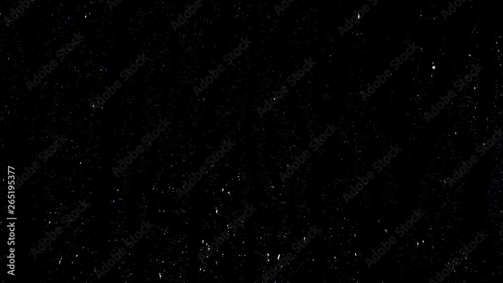 Drops of rain trickling down on black background. Stock Footage. Droplets of water on black glass background running down.