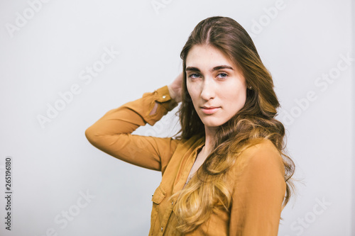 Portrait of beautiful woman with curly long hair on white background. Makeup, fashion, beauty