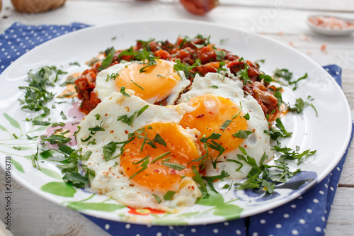 Breakfast with fried eggs and vegetables with tomato sauce