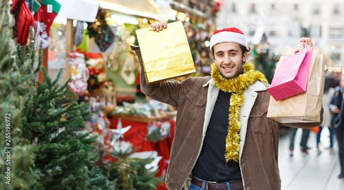 Young man delighted with purchases at Christmas market