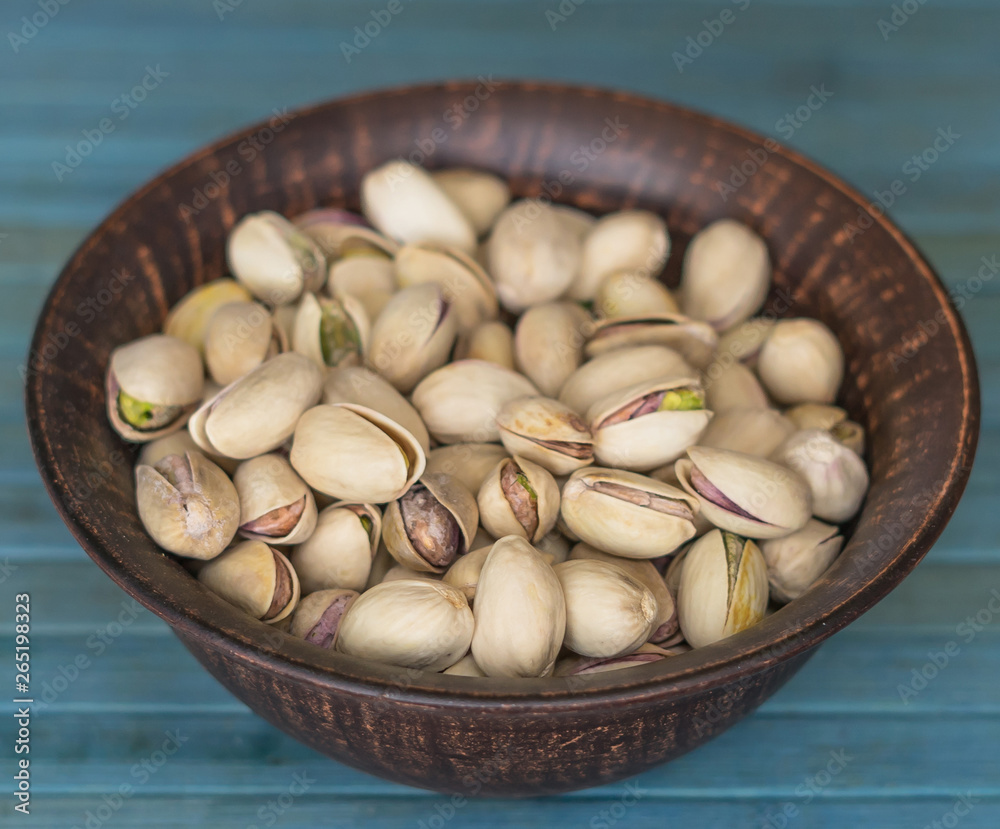 Healthy food for background image close up pistachios nuts. Texture on white grey table top view. Nuts pistachio on the cup plate Healthy food for background image close up pistachios nuts. Texture on white grey table top view. Nuts pistachio on the cup plate