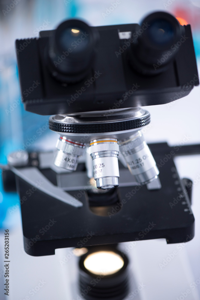 modern scientist uses a microscope in a laboratory