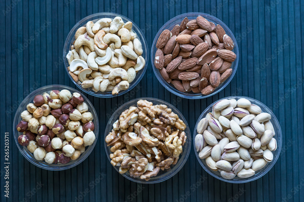 Healthy food. Nuts mix assortment on stone texture top view. Collection of different legumes for background image close up nuts, pistachios, almond, cashew nuts, peanut, walnut. image