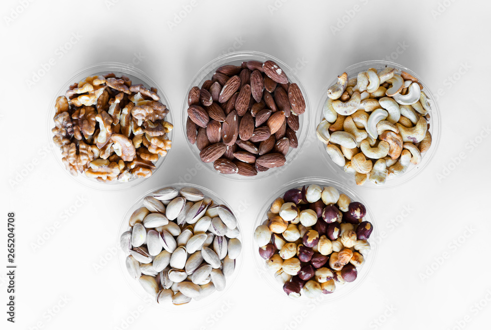 Healthy food. Nuts mix assortment on white grey table top view. Collection of different legumes for background image close up nuts, pistachios, almond, cashew nuts, peanut, walnut. image Healthy food. Nuts mix assortment on white grey table top view. Collection of different legumes for background image close up nuts, pistachios, almond, cashew nuts, peanut, walnut. image