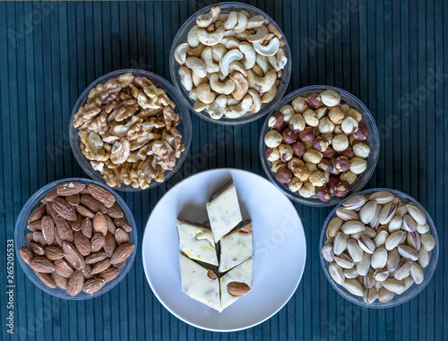 Oriental dessert halva with pistachio, almond, cashew nuts, peanut, walnut on a plate. Image. Healthy food. Nuts mix assortment. sweets, Turkish Delight. Isolated background.. Eastern delicacy
