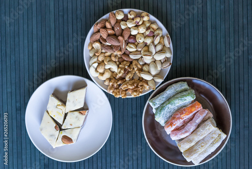 Oriental dessert halva with pistachio, almond, cashew nuts, peanut, walnut on a plate. Image. Healthy food. closeup of sweets from Iran popular Turkish Delight. Isolated on background
