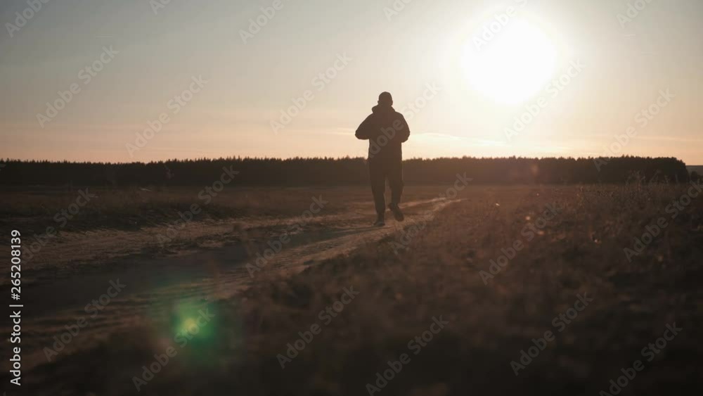 Running man silhouette in sunset time. Outdoor cross-country running. Athletic young man is running in the nature during golden sunset. Healthy lifestyle. Running man silhouette in sunset time. Outdoor cross-country running. Athletic young man is running in the nature during golden sunset. Healthy lifestyle.