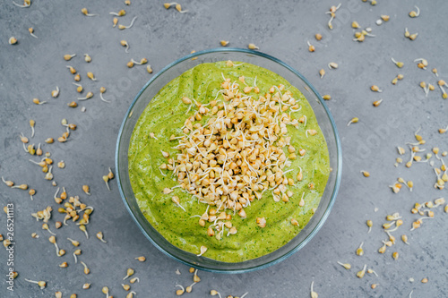 Top view of green smoothie dish in bowl with green buckwheat sprouts. Healthy breakfast. Vegetable dish. Meal full of vitamins. Super bowl photo