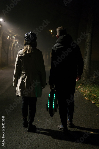 Man bringing an electric unicycle of a woman with helmet protection photo