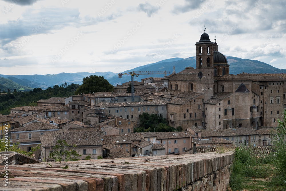 Panoramic view of the ducal palace of Urbino in central Italy with a dramatic sky.
