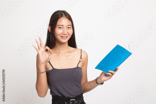 Young Asian woman show OK with a book.