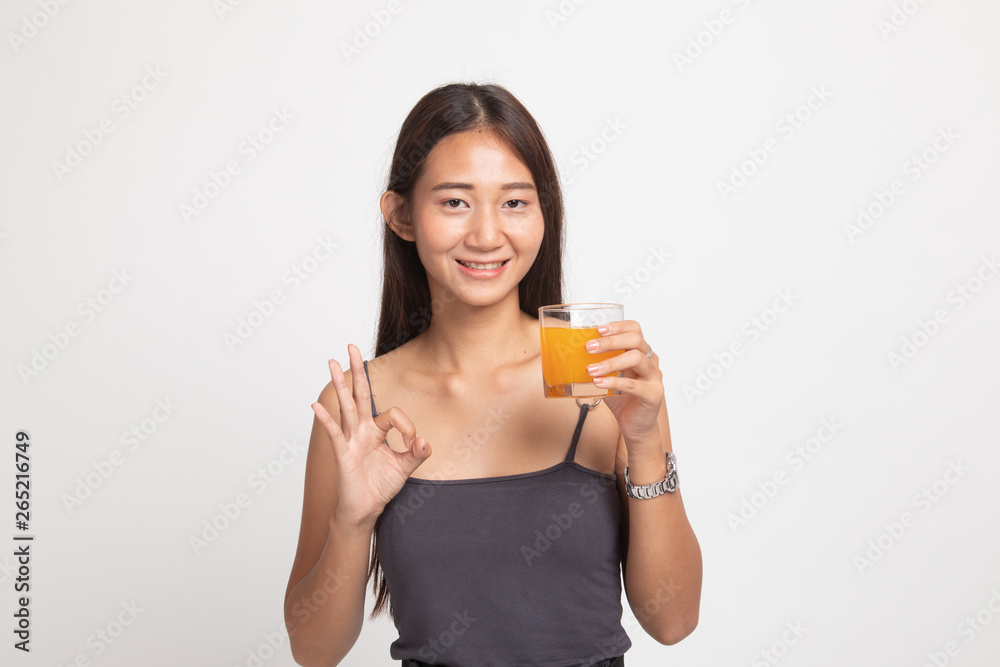 Young Asian woman drink orange juice show OK sign. Young Asian woman drink orange juice show OK sign.