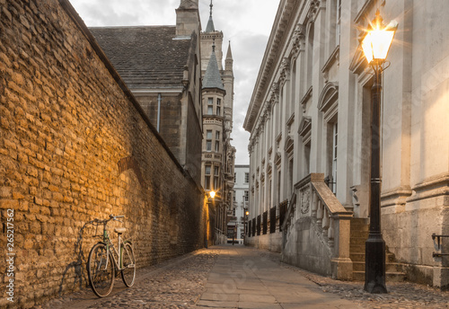 Narrow street at dusk in Cambridge UK, street lights & a bike