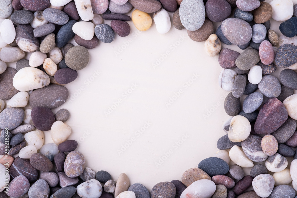 Varied pebbles on white background top view rounded frame Varied pebbles on white background top view rounded frame