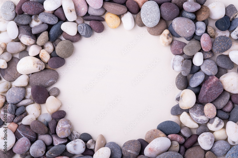 Varied pebbles on white background top view rounded frame Varied pebbles on white background top view rounded frame
