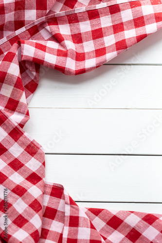Red-white kitchen tablecloth on a white table. View from the top.