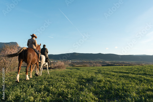 Man and woman riding horses on ranch