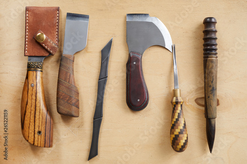 Slika na platnu Top view background image of leatherworking tools lying on wooden table, copy sp