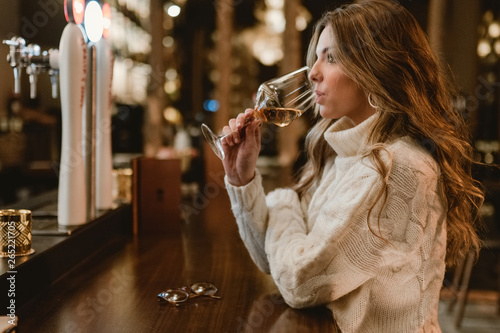 Stylish woman drinking wine in bar photo