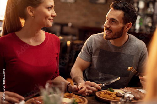 Happy couple communicating while having lunch in a restaurant.