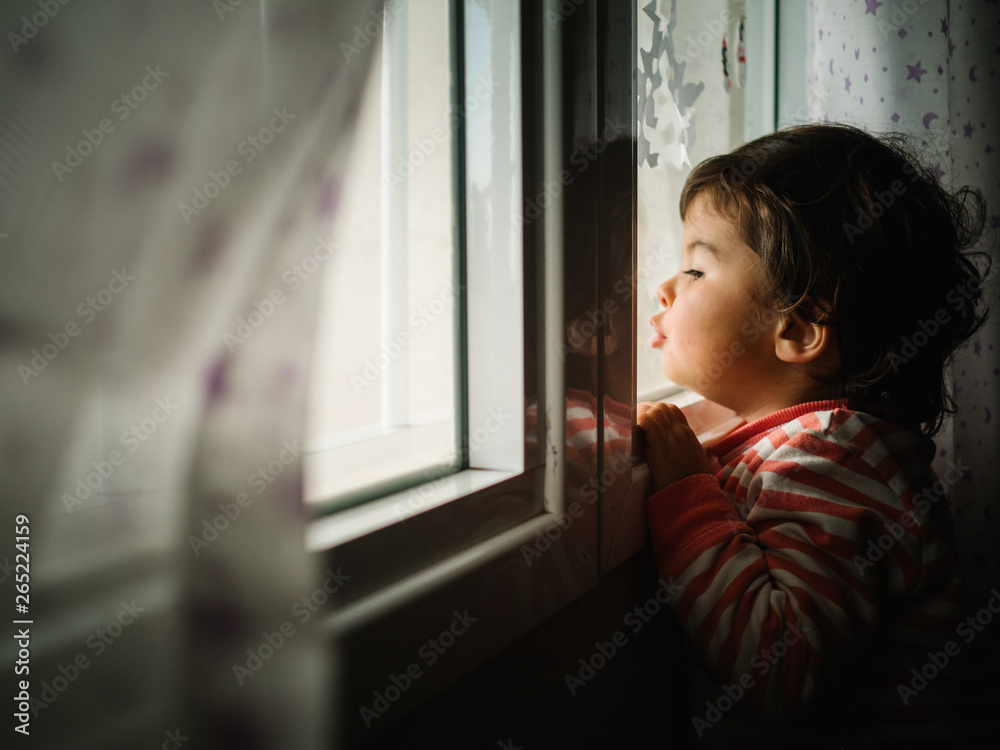 © Patricia Becaroto/ADDICTIVE STOCK - small girl peering through window at home