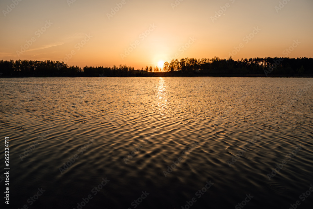 beautiful spring sunset on the lake, amazing nature, warm evening on the river bank