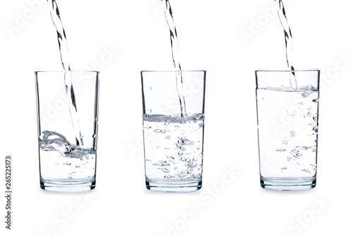 Фотография Pouring water into glass isolated on white background