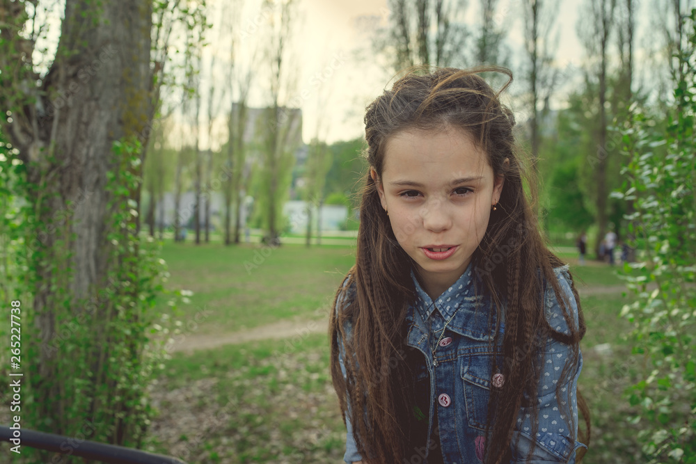 Pleased girl in casual outfit looking. Teen girl posing in the Park Pleased girl in casual outfit looking. Teen girl posing in the Park