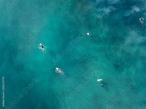 surfers in the water waiting for waves. The water is amazingly beautiful. 