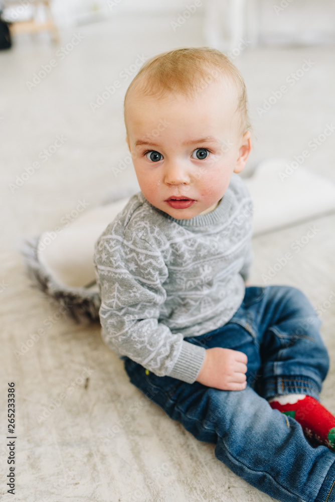 Fototapeta premium Cute little toddler boy sitting on the floor