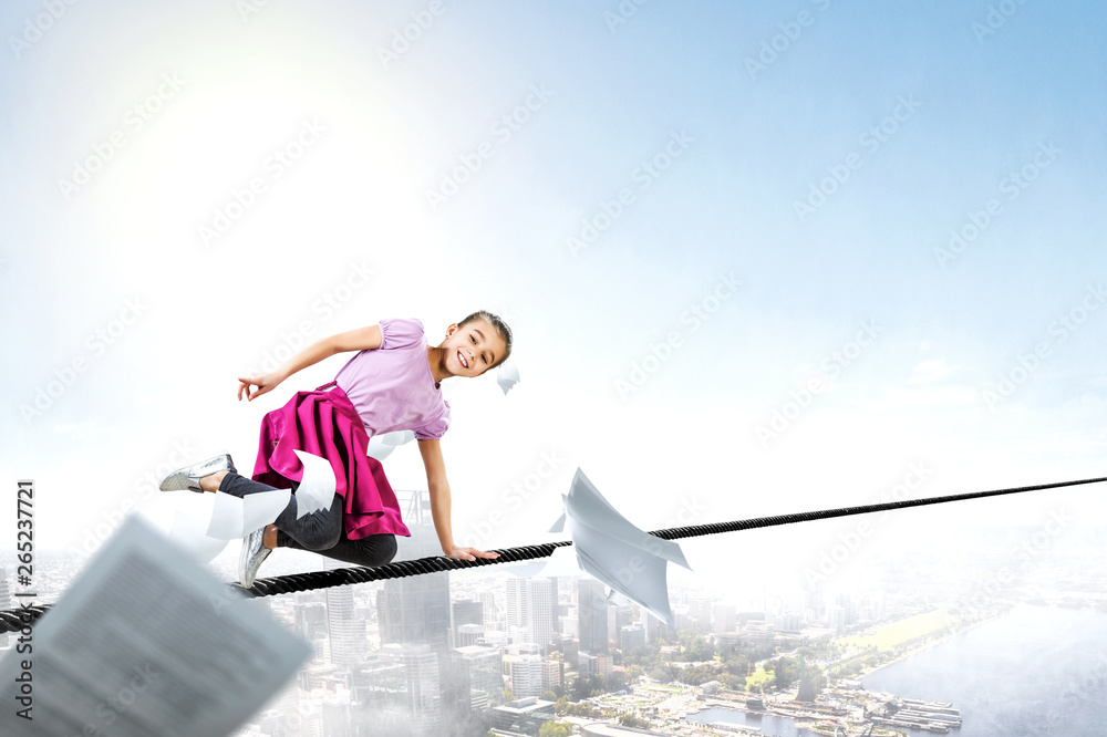 Cute happy little girl on a rope over city. Mixed media Cute happy little girl on a rope over city. Mixed media